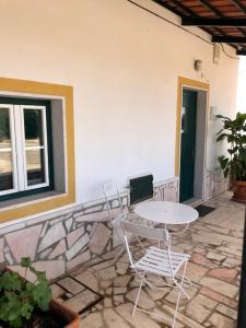 eine Terrasse mit einem Tisch, Stühlen und einem Fenster in der Unterkunft Casas da Saibreira - nº9 in Elvas