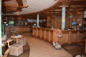 a bar in a restaurant with wooden walls and tables at Hotel Happinger Hof in Rosenheim