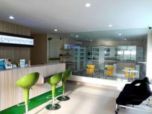 a lobby with green stools and a bar with chairs at Centrana Hotel in Phnom Penh