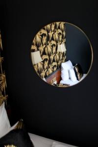 a round mirror on a wall with a bed and a room at Boutique Hotel Krone München in Munich