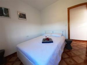 Un dormitorio con una cama blanca con una caja. en Casa Loro Loco B&B en Pedralba