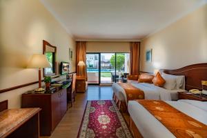 una camera d'albergo con due letti e un soggiorno di Golden Tulip Nizwa Hotel a Nizwa