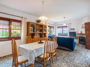 a dining room and living room with a table and chairs at Holiday Home Can Fulgencio II by Interhome in Cala Llenya