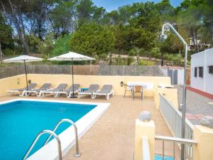 una piscina con sillas y sombrillas en un patio en Holiday Home Can Fulgencio II by Interhome en Cala Llenya