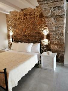 1 dormitorio con cama y pared de piedra en Dormire nel Borgo, en Bovino