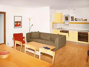 a living room with a couch and a table at Holiday Home Silz am Fleesensee-3 by Interhome in Silz