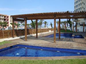pérgola de madera y piscina con terraza en Apartment Cristal Mar by Interhome, en Empuriabrava