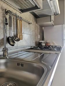 a kitchen with a stainless steel sink and a stove at Casa Ibla in Siracusa