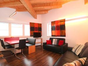 sala de estar con sofá, mesa y sillas en Apartment Am Bärenkopf-2 by Interhome, en Maurach