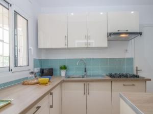 a kitchen with white cabinets and a sink at Holiday Home D'Ibis by Interhome in Empuriabrava