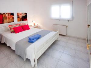 a bedroom with a large white bed with red pillows at Holiday Home D'Ibis by Interhome in Empuriabrava