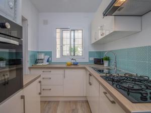 a kitchen with white cabinets and a stove at Holiday Home D'Ibis by Interhome in Empuriabrava