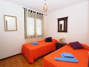 - 2 lits dans une chambre avec des draps orange dans l'établissement Holiday Home Triangulo by Interhome, à Empuriabrava