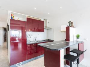 cocina roja con fregadero y encimera en Apartment Bahia-7 by Interhome, en Empuriabrava