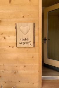 a sign on a wooden wall with a heart on it at Apartment Andrea by Interhome in Lenk