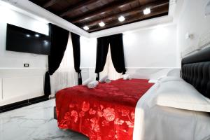 - une chambre avec un lit rouge et une télévision à écran plat dans l'établissement Relais Parlamento, à Rome