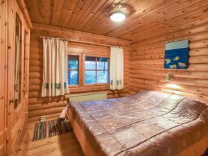a bedroom with a bed in a log cabin at Holiday Home Niitsinniemi by Interhome in Laamala