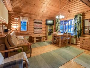 a log cabin living room with a table and a television at Holiday Home Niitsinniemi by Interhome in Laamala