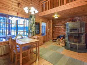 a dining room with a table and a wood stove at Holiday Home Niitsinniemi by Interhome in Laamala