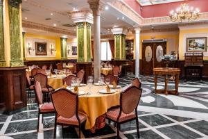 ein Restaurant mit Tischen und Stühlen und einem Kronleuchter in der Unterkunft Hotel Reina Cristina in Granada