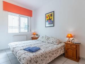 a bedroom with a bed and two windows at Holiday Home Green House by Interhome in Empuriabrava