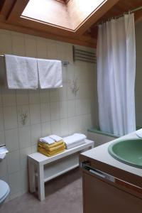 La salle de bains est pourvue d'un lavabo, d'une douche et de serviettes. dans l'établissement Apartment Stöckli by Interhome, à Lenk im Simmental