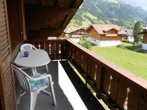 d'une terrasse avec une table et des chaises sur un balcon. dans l'établissement Apartment Stöckli by Interhome, à Lenk im Simmental