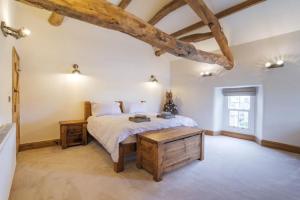 a bedroom with a bed and a wooden table at 5 Star Cottage on the Green with Log Burner - Dog Friendly in Austwick