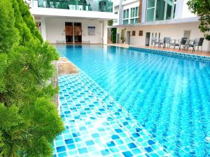 a swimming pool with blue tiles on the side of a building at Hinoki Hotel - ONSEN Chiang Mai in Chiang Mai