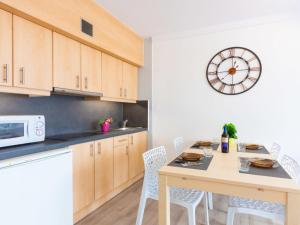 エンプリアブラバにあるApartment Vista Bahia-1 by Interhomeのテーブルと壁に時計があるキッチン +18枚の写真