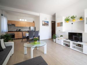 a living room with a table and a kitchen at Apartment Judita by Interhome in Jadranovo