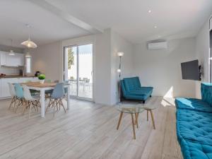 een woonkamer met een blauwe bank en een tafel bij Holiday Home Sangha by Interhome in Empuriabrava