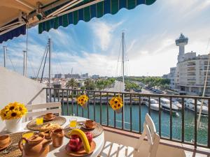 d'un balcon avec une table et de la nourriture et une vue sur le port. dans l'établissement Apartment Caballito de Mar by Interhome, à Empuriabrava