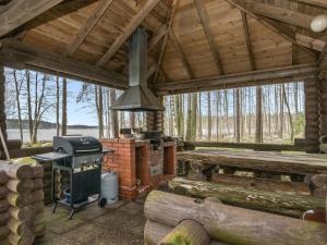 eine abgeschirmte Veranda eines Blockhauses mit einem Herd in der Unterkunft Holiday Home Tavintupa by Interhome in Pertunmaa + 22 Fotos