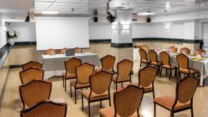 ein Konferenzraum mit Tischen und Stühlen und einer Leinwand in der Unterkunft Hotel Reina Cristina in Granada