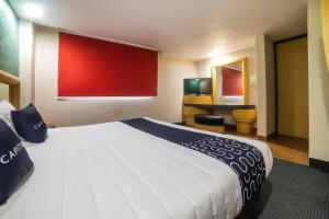 a large bed in a room with a red wall at Capital O Autoparador Del Valle,Centro Industrial Tlalnepantla in Mexico City