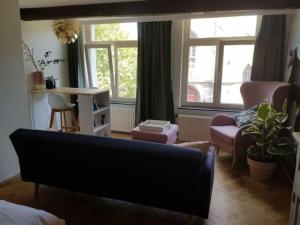 - un salon avec un canapé, une table et une fenêtre dans l'établissement Luxurious Loft in Maastricht City Center, à Maastricht