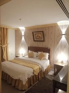 a bedroom with a large bed with two lights on it at ضيافه السعاتى 1 للعوائل فقط in Al Khobar