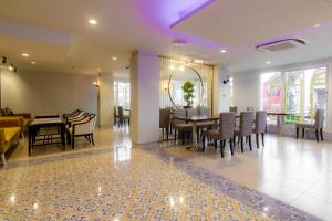 a dining room and living room with a table and chairs at Montree Phuket Hotel in Phuket Town