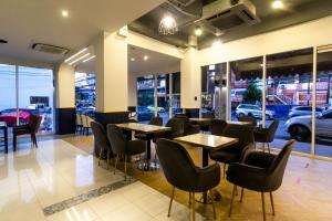 a restaurant with tables and chairs and cars in the window at Montree Phuket Hotel in Phuket Town