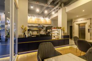 a restaurant with chairs and a counter with a kitchen at Montree Phuket Hotel in Phuket Town