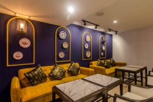 a living room with yellow couches and plates on the wall at Montree Phuket Hotel in Phuket Town