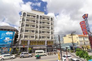 a tall white building on a busy city street at Montree Phuket Hotel in Phuket Town