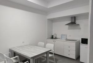 
a kitchen with a table and chairs and a refrigerator at Aparthotel Puerto Cala Vadella in Cala Vadella

