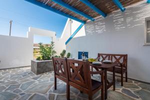a dining room with a table and chairs on a patio at Heliovasilema Studios in Pollonia