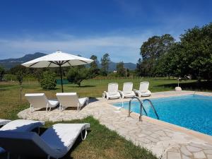 a group of chairs and an umbrella next to a pool at Monica di Sorbo in Sorbo-Ocagnano