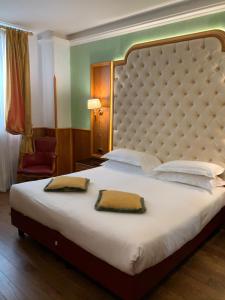 a bedroom with a large bed with two towels on it at Hotel Vittoria in Milan