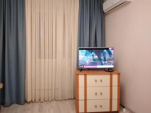 een televisie bovenop een dressoir in een kamer bij Dacia Apartments in Chişinău