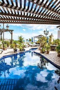 una piscina con pérgola y agua azul en Casablanca Fuerteventura Morro Jable Suites, en Morro del Jable