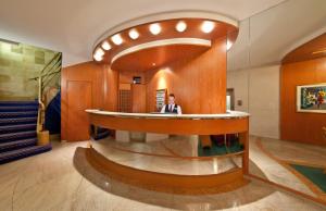 a man sitting at a counter in a lobby at Novum Hotel Boulevard Stuttgart City in Stuttgart